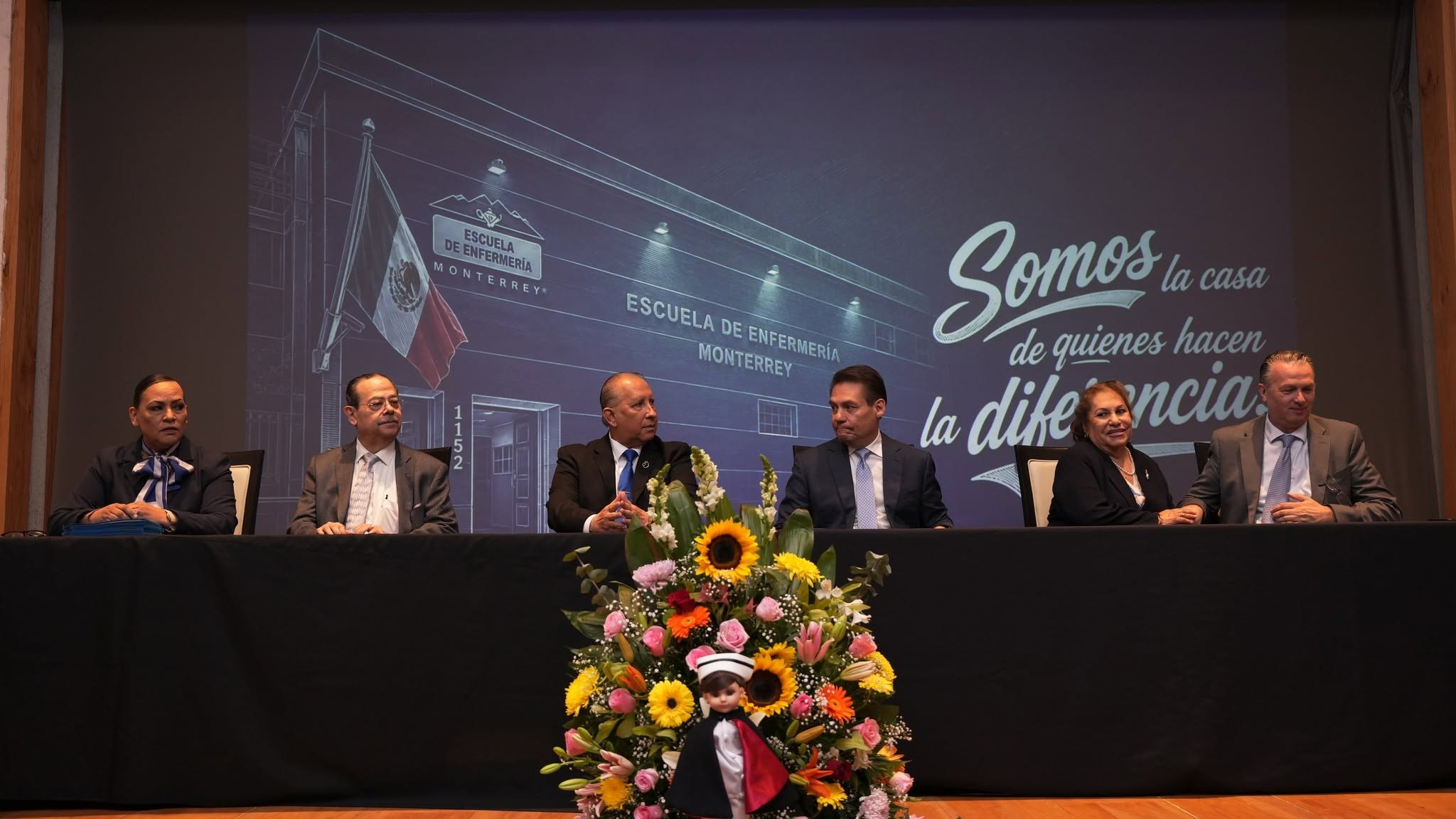 Autoridades y directivos de la escuela en el presídium, frente a la proyección «Somos la casa de quienes hacen la diferencia»