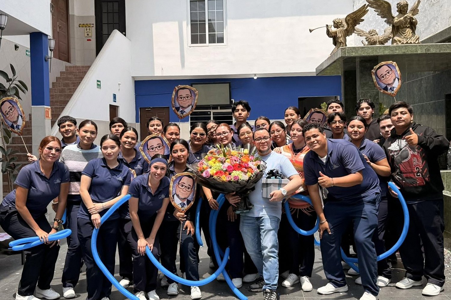 Alumnos de Enfermería reunidos en el patio de la escuela con un ramo de flores