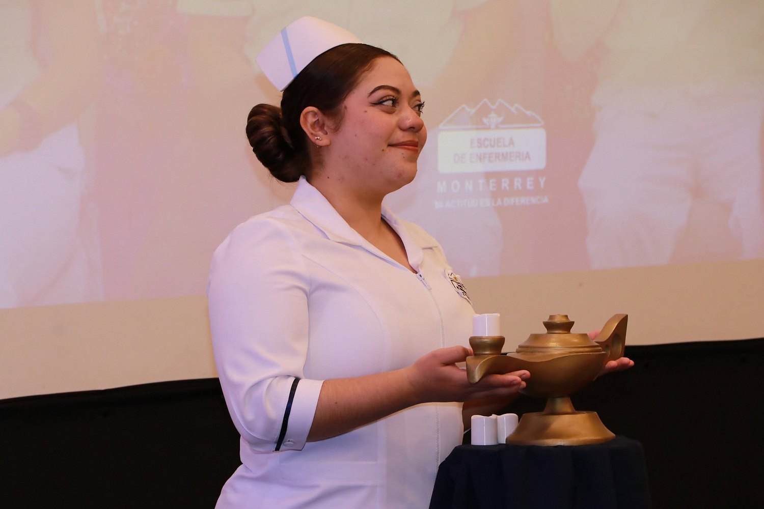Alumna de Enfermería sostiene la lámpara durante la ceremonia